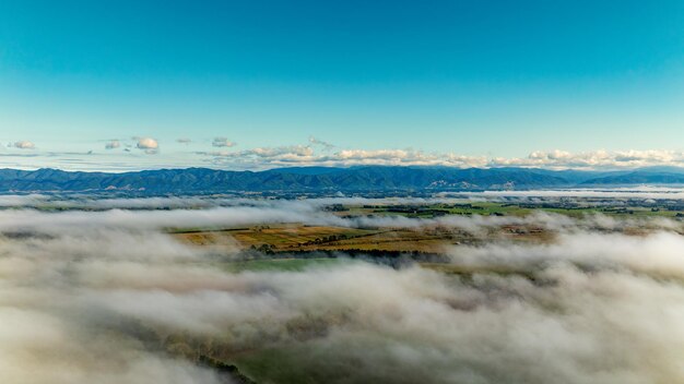 Photo scène aérienne de nuages bas dans la vallée avec la chaîne de montagnes au-dessus des nuages