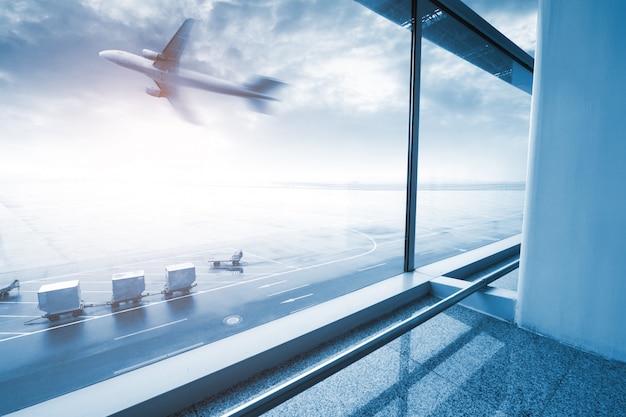 Scène d&#39;aéroport moderne de mouvement de passagers flou avec fenêtre à l&#39;extérieur.