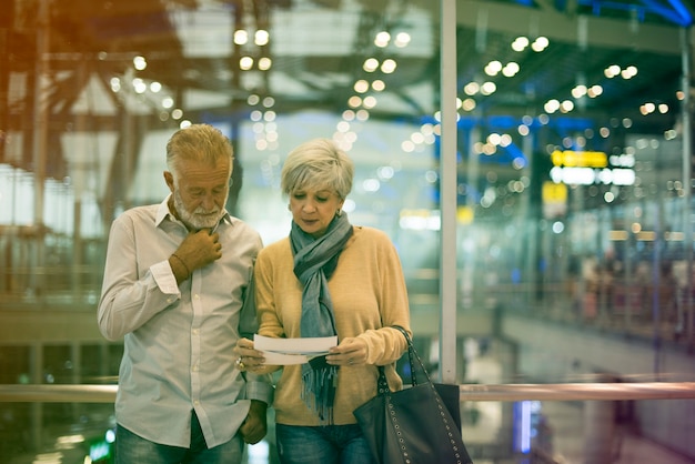 Scène d'aéroport de voyage de couples supérieurs