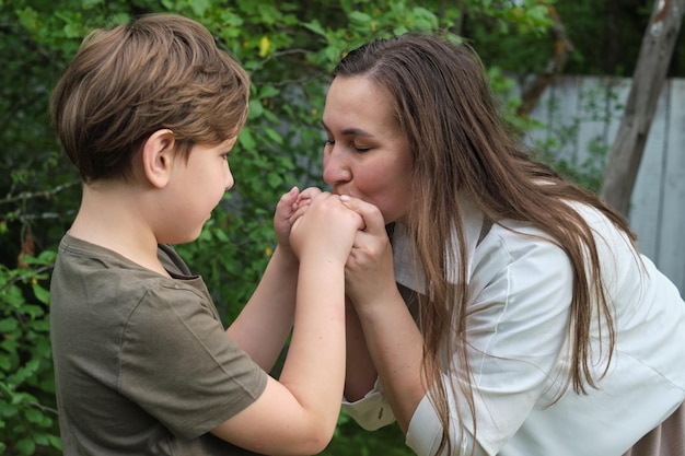 Une scène attachante d'une mère et de son fils partageant une blague et un câlin dans un jardin serein mettant en valeur le