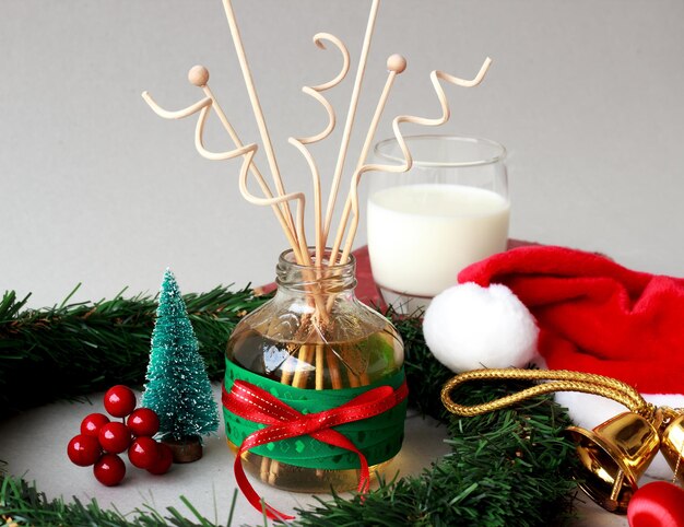 Photo scène du matin de noël avec du lait et du diffuseur de roseau le père noël se repose avec du lait et du parfum