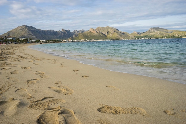 Scène méditerranéenne, rive de la mer Méditerranée avec des empreintes pieds nus de personnes en été