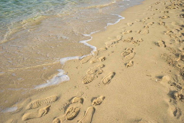 Scène méditerranéenne de vacances, rive de la mer Méditerranée avec des empreintes pieds nus de personnes en été