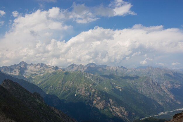 Scène de montagnes avec un ciel nuageux dramatique dans le parc national de Dombay, Caucase, Russie. Paysage d'été et journée ensoleillée