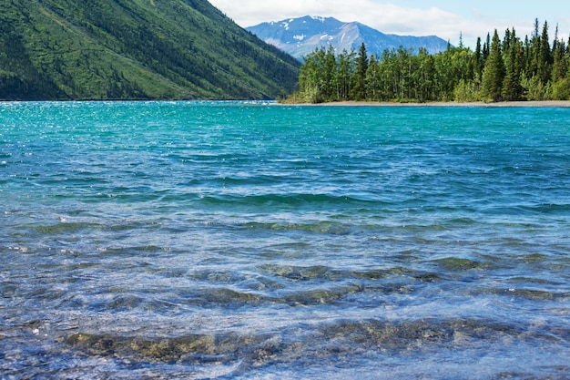 Photo scène sereine au bord du lac de montagne au canada avec reflet des rochers dans l'eau calme.