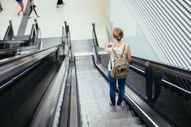 Photo scène de voyage à une gare jeune fille et un escalier