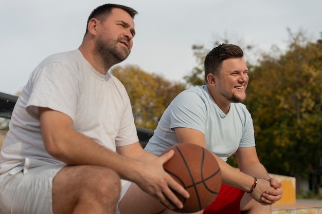 Des scènes authentiques d'hommes de taille plus grande jouant au basket-ball