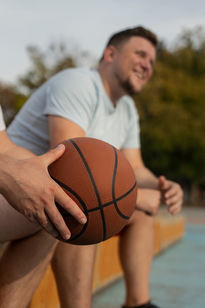 Photo des scènes authentiques d'hommes de taille plus grande jouant au basket-ball