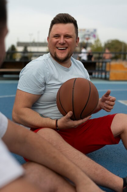 Photo des scènes authentiques d'hommes de taille plus grande jouant au basket-ball