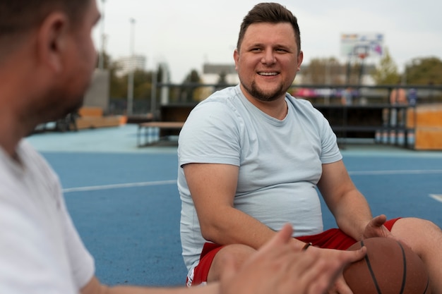 Photo des scènes authentiques d'hommes de taille plus grande jouant au basket-ball