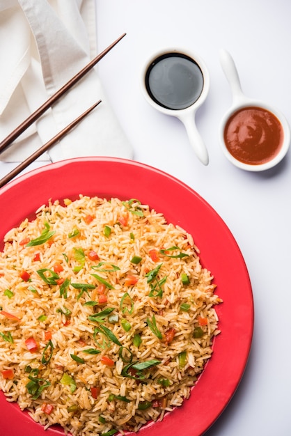 Schezwan Fried Rice Masala est un aliment indochinois populaire servi dans une assiette ou un bol avec des baguettes. mise au point sélective