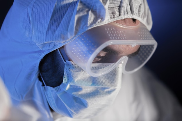 science, chimie, biologie, médecine et concept humain - gros plan sur le visage d'un scientifique portant des lunettes et un masque de protection au laboratoire de chimie