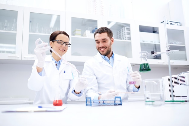 science, chimie, technologie, biologie et concept humain - jeunes scientifiques avec pipette et test de fabrication de verre ou recherche en laboratoire clinique