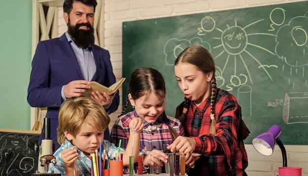 Science et éducation laboratoire de chimie retour à l'école enfants heureux enseignant enfants faisant des expériences scientifiques faisant des expériences avec des liquides dans un laboratoire de chimie Améliorer la médecine moderne