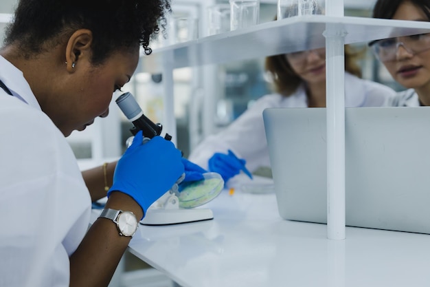science technologie chimiste développant un concept chercheuse scientifique médicale ou médecin ou étudiant regarde dans un microscope dans un laboratoire moderne