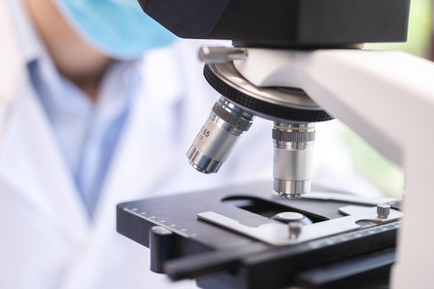 Scientifique analysant une lame de microscope au laboratoire Jeune femme technicienne examine un échantillon histologique une biopsie dans le laboratoire de recherche sur le cancer