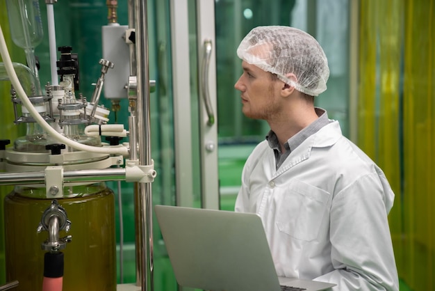 Scientifique apothicaire enregistrant les données de l'extracteur d'huile de CBD en laboratoire