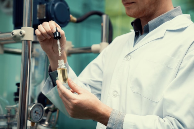 Un scientifique ou un apothicaire extrait de l'huile de chanvre CBD à des fins médicinales en laboratoire