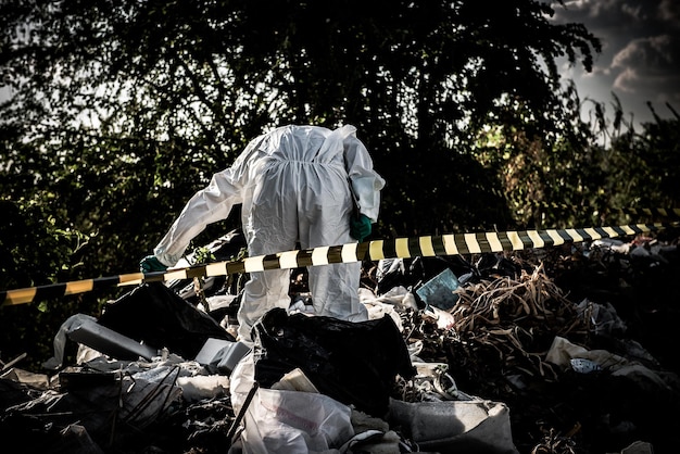 Photo un scientifique asiatique porte une combinaison de protection chimique pour vérifier le danger de travail chimique dans une zone dangereuse collecte d'échantillons en cas d'enquête sur le virus corona déclenchée par la chine