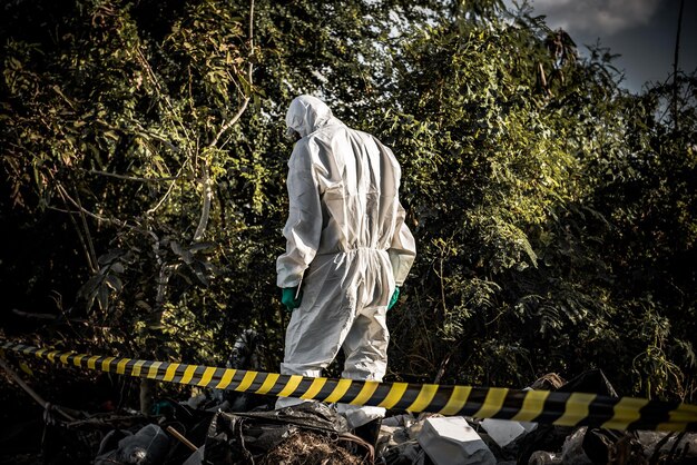 Un scientifique asiatique porte une combinaison de protection chimique pour vérifier le danger de travail chimique dans une zone dangereuse Collecte d'échantillons en cas d'enquête sur le virus Corona déclenchée par la Chine