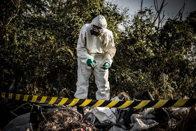 Un scientifique asiatique porte une combinaison de protection chimique pour vérifier le danger de travail chimique dans une zone dangereuse Collecte d'échantillons en cas d'enquête sur le virus Corona déclenchée par la Chine