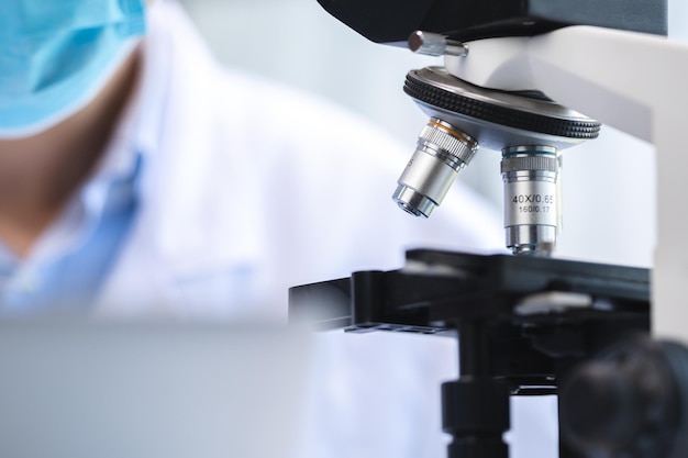 Scientifique en biotechnologie utilisant un microscope scientifique pour la recherche en équipement de laboratoire de médecine biologique pour la science chimique ou l'analyse microbiologique en termes d'expérience de technologie médicale