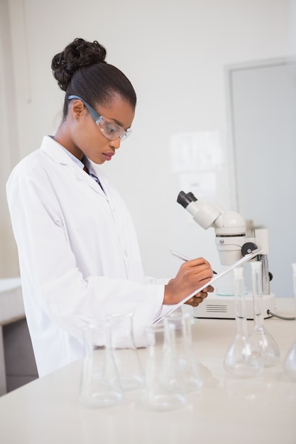 Scientifique concentré prenant des notes