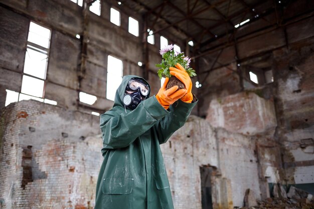 Photo un scientifique dosimétriste inspecteur de rayonnement dans des vêtements de protection et un masque à gaz examine la zone de danger gros plan catastrophe écologique de fleurs