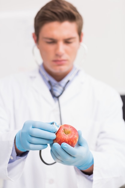 Scientifique écoute pomme avec stéthoscope