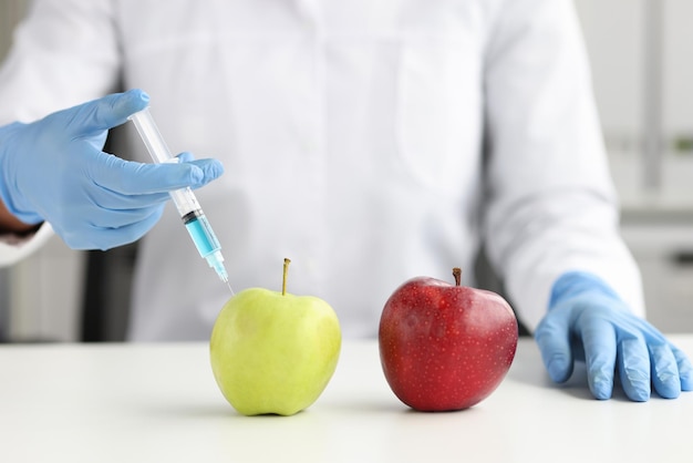 Un scientifique fait une injection dans une pomme en laboratoire