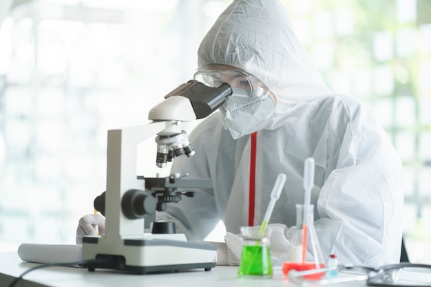 Scientifique médical analysant des lames de microscope dans un laboratoire de recherche pour le vaccin ou le sérum nCoV 2019.