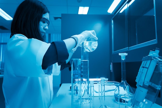 Photo un scientifique mélange des produits chimiques avec la machine à secouer avant l'expériencemélange avec des échantillons dans des tubes à essaiscientifique thaïlandais travaillant dans le laboratoire