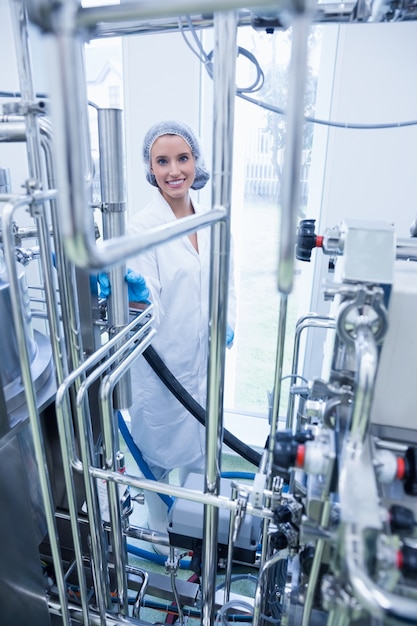 Photo scientifique souriant derrière un tuyau métallique