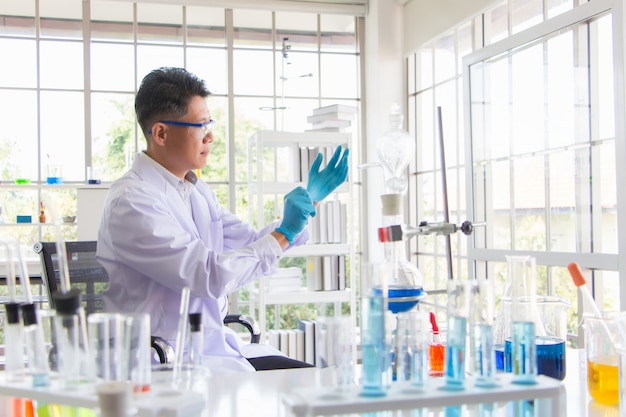 Des scientifiques chevronnés, experts en chimie et microbiologie, portent des gants et des dispositifs de protection chimique dans un laboratoire rempli de dispositifs scientifiques lors de l'épidémie du coronavirus.