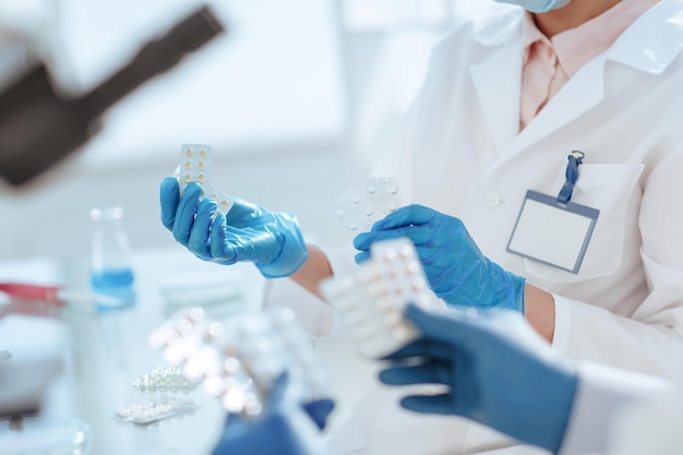 Photo des scientifiques avec des échantillons de nouveaux médicaments assis à une table de laboratoire