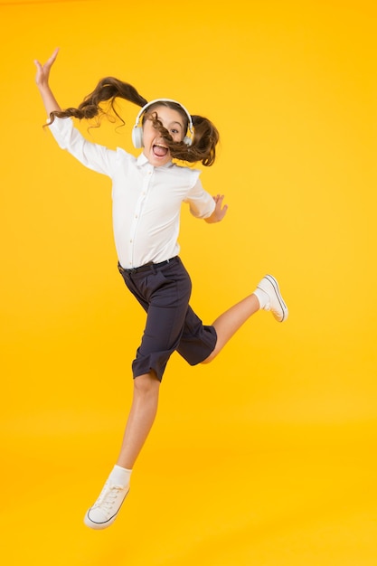 Scolarité en ligne. Leçon de danse. L'enfant apprécie le son de la musique. Enseignement audio. Enseignement à domicile. Casque d'écoute pour petite fille. Enfant heureux écouter de la musique. Chantez la chanson. Livre audio. Concept éducatif et amusant.