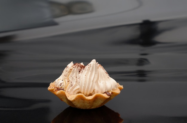 Un scone au chocolat est posé sur un capot de voiture noir.