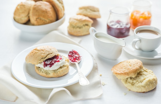 Scones avec crème et confiture de fruits et tasse de café