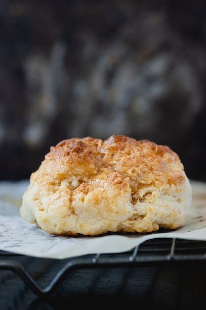 Scones sucrés faits maison avec du miel sur la grille du four sur une surface claire. Copiez l'espace.