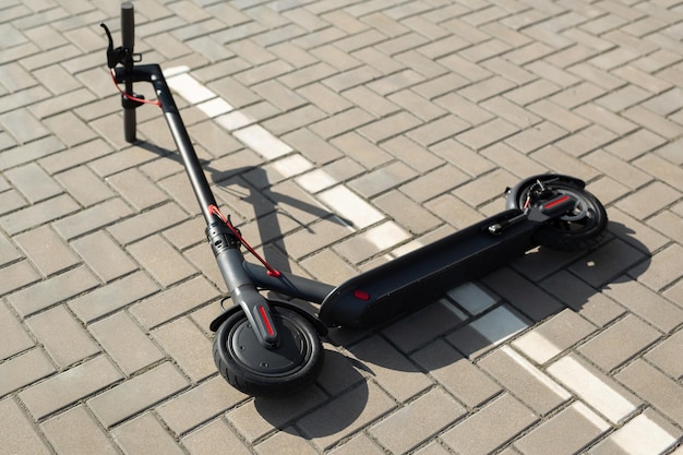 Un scooter électrique est allongé sur le trottoir