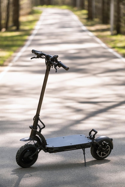 Scooter électrique noir debout sur le marchepied dans la rue