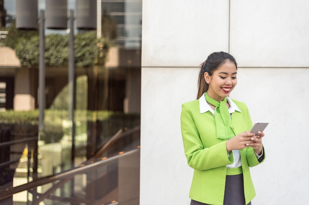 Scort femme avec tablette et téléphone portable souriant