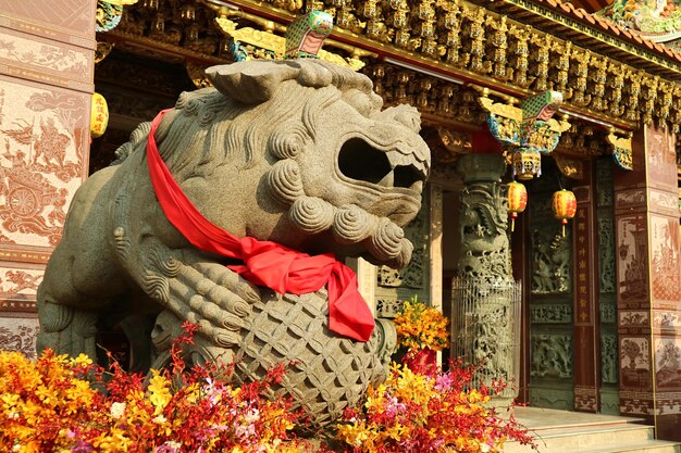 Sculpture chinoise de lion gardien masculin devant un sanctuaire bouddhiste chinois