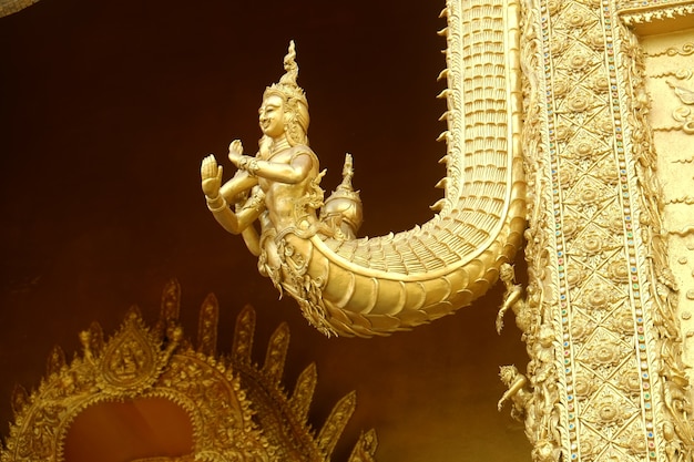 Sculpture dorée de Naga sur la porte du temple Wat Sri Panthon.