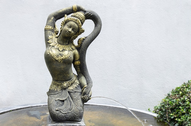 Photo sculpture de femme avec fontaine d'écoulement d'eau, décoration de statue dans le jardin