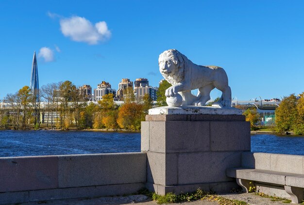 Photo sculpture d'un lion avec une balle sur l'arrière-plan de l'immeuble lakhta center elagin island saint petersburg