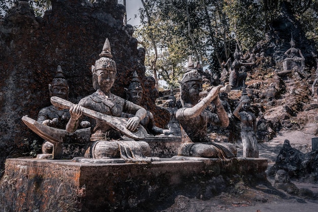 Sculptures en pierre de divinités bouddhistes jouant de la musique parmi les arbres dans le jardin magique de Tarnim Samui Thaïlande