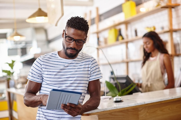 Photo se connecter avec un café portrait d'un propriétaire de bistrot à l'aide d'une tablette numérique