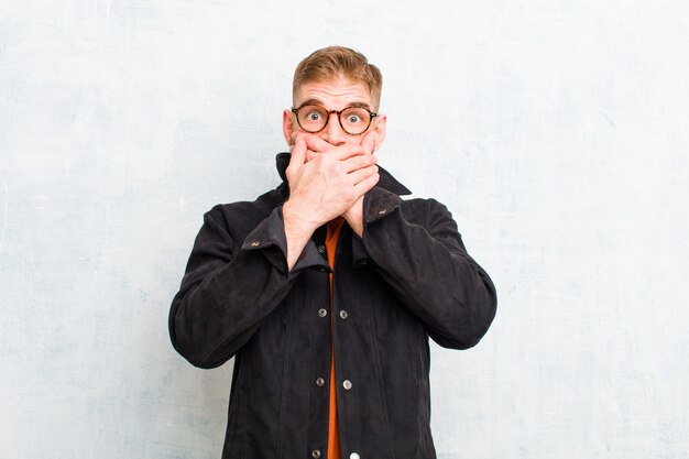 se couvrir la bouche avec les mains avec une expression choquée et surprise, garder un secret ou dire oups