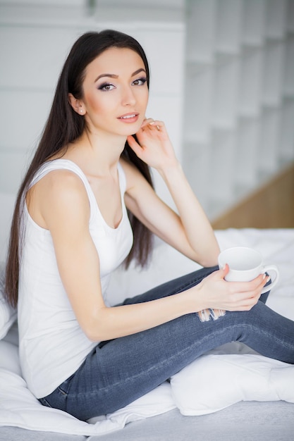 Se détendre sur le lit pendant le week-end Belle femme se détendre sur un lit et avoir l'air heureux